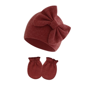 Detailed knit texture of heather red baby beanie with large bow and anti-scratch mittens