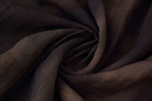 Vista macro della trama setosa e della sfumatura marrone scuro del tessuto della gonna midi