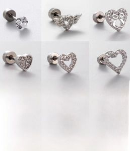 Macro detail of six silver titanium steel heart studs with zircon butterfly designs