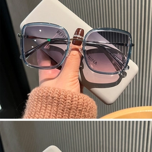 Détail de lunettes de soleil carrées beiges avec branches en métal fin et verres dégradés