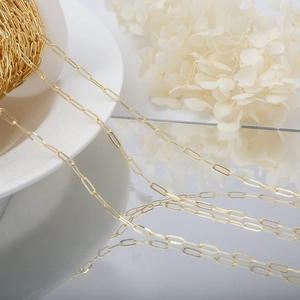Macro view of 14K gold-plated paperclip chain on a white plate for DIY jewelry making