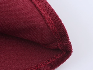Detailed macro view of deep red chenille fabric texture and high-quality overlock stitching