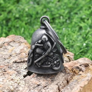 Detailed close-up of a vintage steel biker guardian bell with grim reaper relief