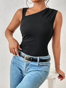 Top de punto ajustado negro con un hombro sin mangas combinado con vaqueros azules