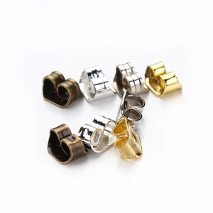 Detailed macro view of mixed butterfly earring backings in gold, silver, and bronze finishes