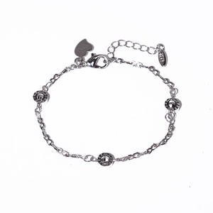 Macro shot of S925 silver bracelet featuring heart pendant and faceted silver beads
