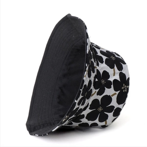 Detail of reversible cotton bucket hat showing black and white floral pattern and stitching