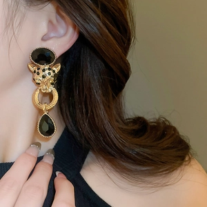 Detailed view of vintage leopard head earrings with black gemstones and gold plating