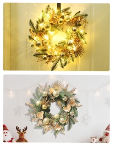 Detailed view of green Christmas wreath with gold baubles and warm LED lighting effect