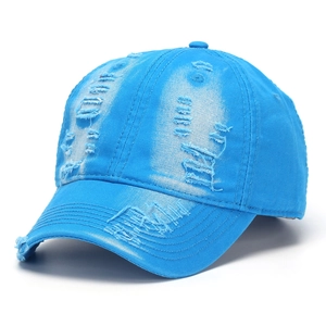 Close-up of blue distressed denim baseball cap with vintage worn-out holes and texture