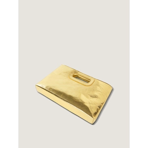 Close-up of golden woven texture and cutout handle on modern metallic handbag