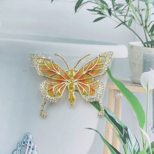 Elegant gold butterfly brooch with orange gradient enamel and sparkling rhinestones