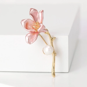 Elegant pink flower brooch with golden branch and pearl on minimalist white background