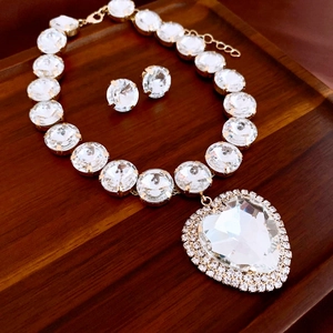 Nahaufnahme von Vintage-Herzanhänger-Halskette und passendem Diamant-Ohrstecker-Set