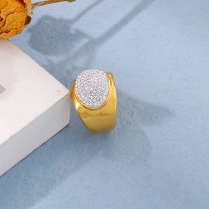 Detail of gold titanium ring with micro-pave crystals on light blue background