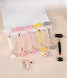 Detailed view of dual-headed facial massagers in various natural gemstone colors and styles