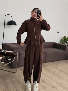 Deep brown two-piece lounge set featuring a zip-up sweatshirt and wide-leg trousers
