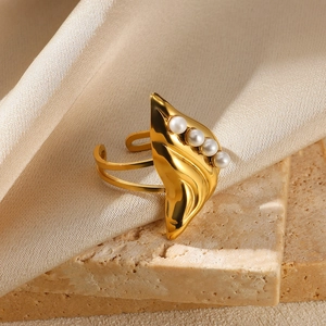Detail of adjustable gold ring featuring a leaf design and four white pearls on stone