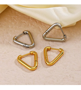 Detailed view of minimalist triangular earrings in gold and silver finishes on silk fabric