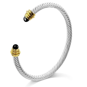 Classic stainless steel cable twist bracelet with gold accents and black sphere tips