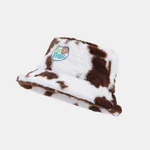 Close-up of fluffy cow print plush bucket hat with Sea Breeze embroidered patch detail