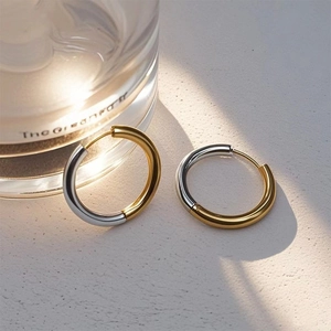 Close-up of dual-tone gold and silver hoop earrings with a high-polished finish