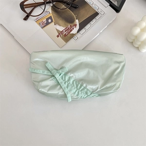 Dettaglio di un astuccio verde menta in tessuto lucido con un grazioso fiocco.