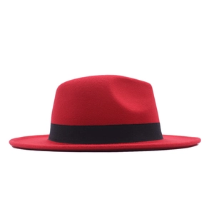 Detail view of a red wool felt fedora hat featuring a stylish black decorative ribbon band