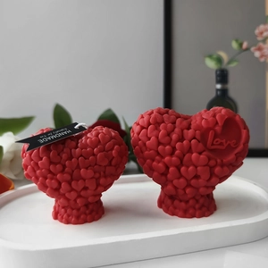 Detailed view of red heart-shaped candles with embossed Love text and elegant tray setup