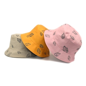 Détail de bobs en coton avec imprimés papillon en gris, jaune et rose pastel