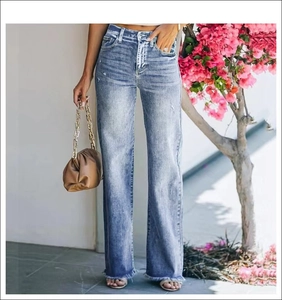 Detail shot of distressed hem and light blue wash on high waist wide leg denim pants