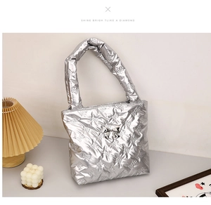 Macro detail of silver puffer tote bag with bow quilting and 3D metallic bow