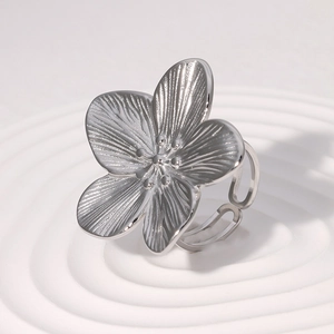 Detailed macro view of silver flower-shaped adjustable ring with textured petals