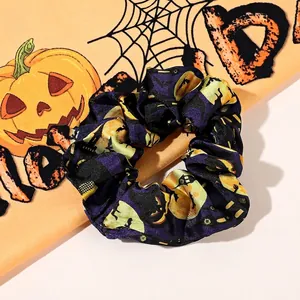 Detail of purple satin Halloween scrunchie with pumpkin and bat patterns on festive fabric