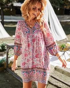 Détails du col en V et de l'imprimé floral sur une robe d'été rose de style bohème