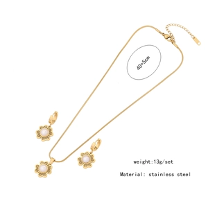 Detail view of flower-shaped stainless steel necklace and earrings set with pearls