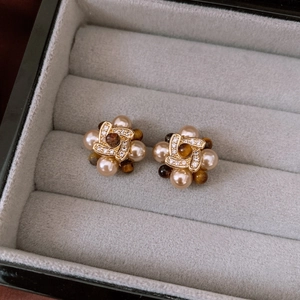 Detail of vintage gold-plated stud earrings with pearls and brown tiger eye stones