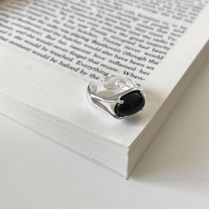 Detail of S925 sterling silver ring with black onyx stone resting on book pages