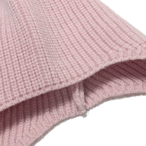 Macro shot of pink ribbed knit fabric showing thick double-layer texture and quality stitching