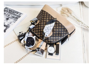 Flat lay of mini shell crossbody bag with silk scarf, sunglasses and golden chain strap