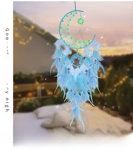 Macro detail of moon-shaped dream catcher with soft blue feathers and glowing beads