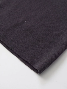 Detailed macro view of high-quality dark grey knitted fabric texture and hem edge stitching
