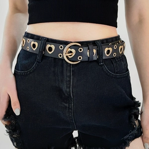 Detail of black leather punk belt with golden heart-shaped buckle and eyelets on a model