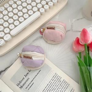 Detailed view of quilted nylon earphone pouches with large pearl charms and zip closure