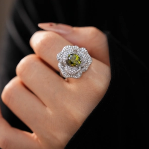 Detailed view of an olive green oval gemstone ring with a 3D rose flower design
