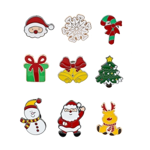 Flat lay of 9 colorful Christmas enamel pins including Santa, reindeer, and snowmen