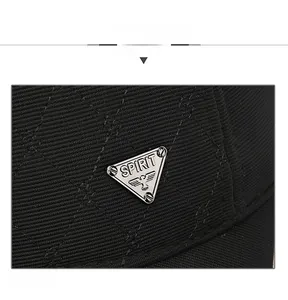 Detail of quilted black baseball cap featuring a metal Spirit logo with eagle emblem