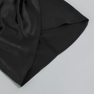 Gros plan détaillé de l'ourlet d'une robe en satin noir avec couture fine et fini soyeux