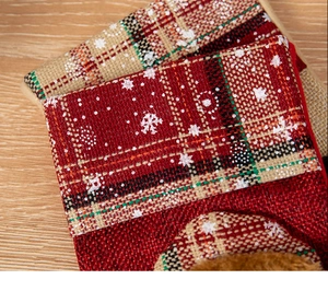 Macro detail of red plaid Christmas stocking with snowflake print and faux fur trim