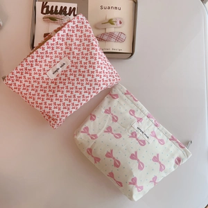 Close-up of floral and bow pattern fabric cosmetic bags with metal zipper closure